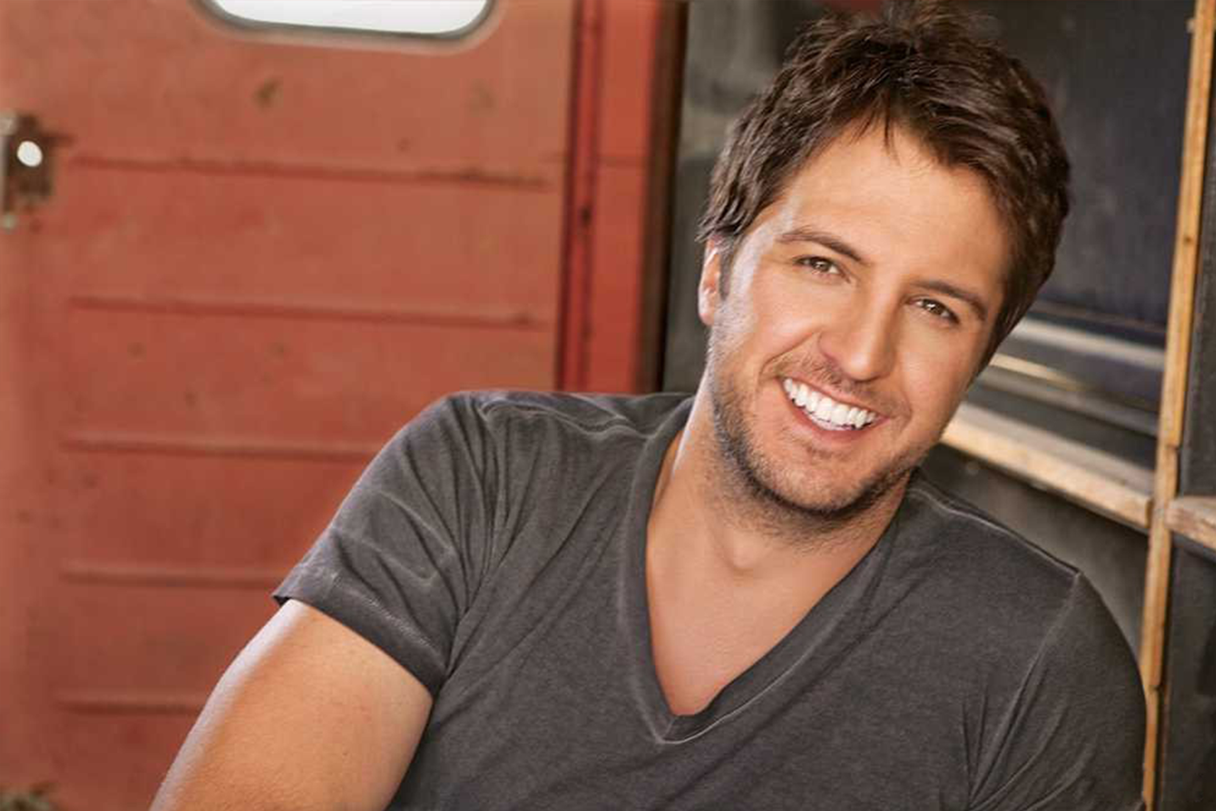 Luke Bryan leaning on a window smiling